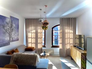 a living room with a couch and a tv at Apartmán Anna in Komárno