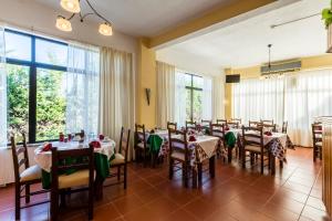 een eetkamer met tafels en stoelen en grote ramen bij Manta Guest - Bed & Breakfast in Manta Rota