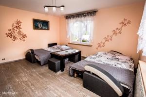 ウストシキ・ドルネにあるPokoje u Honoratyのベッド2台とテーブルが備わる客室です。