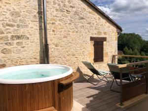 bañera de hidromasaje en una terraza junto a un edificio en Les Hauts de Gageac Maison d'Hôtes de Charme, en La Roque-Gageac