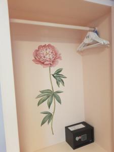 ein Bild einer rosa Blume an der Wand in der Unterkunft Caluga House in Piano di Sorrento