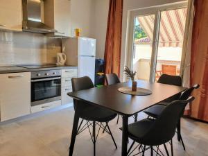 een keuken met een tafel en stoelen in een keuken bij Apartments Ribarić in Rab