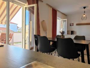 een eetkamer met een tafel en stoelen en een balkon bij Apartments Ribarić in Rab