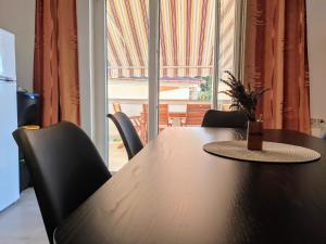 een tafel en stoelen met een tafel en een raam bij Apartments Ribarić in Rab +44 foto's