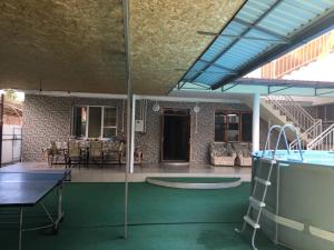 un patio con mesa de ping pong y piscina en Guest House Ostrov Sokrovishch, en Loo