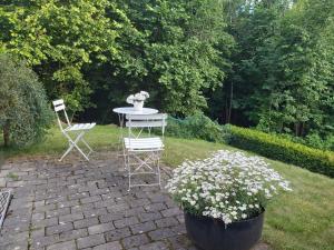 a table and chairs in a garden with flowers at Huset i skogen in Moss
