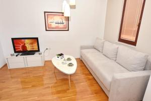 een woonkamer met een witte bank en een tafel bij SI Apartments Ohrid with free parking in Ohrid