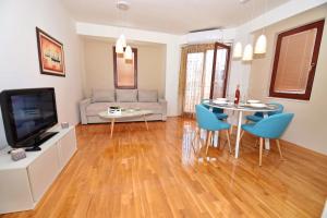 a living room with a television and a table and chairs at SI Apartments Ohrid with free parking in Ohrid