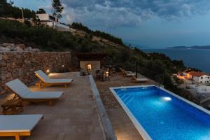 a villa with a swimming pool on a hill at Exclusive Villa Almissa with swimming pool and sea view in Lokva Rogoznica
