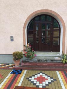 una puerta delantera de una casa con suelo de mosaico en Sadyba Hatynka, en Yaremche