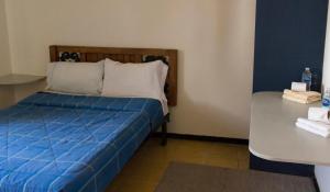um quarto com uma cama com lençóis azuis e uma mesa em Departamento 7/7 em Tlaxcala de Xicohténcatl