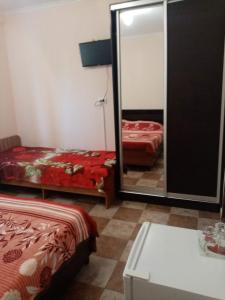 a bedroom with two beds and a mirror at Guest House Ostrov Sokrovishch in Loo