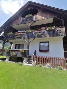 a house with a balcony with flowers on it at Apartment V&N, LAKE BOHINJ in Bohinj