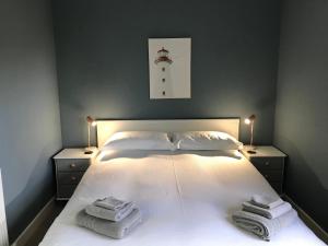 una camera da letto con un letto bianco e asciugamani di The West Lodge -dog friendly, cosy, Scottish Borders cottage a Berwick-Upon-Tweed