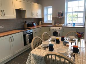 a kitchen with a table and chairs and a table at The West Lodge -dog friendly, cosy, Scottish Borders cottage in Berwick-Upon-Tweed