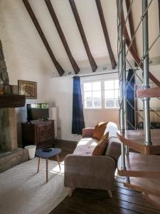 a living room with a couch and a tv at Ti Baou in Châteauneuf-du-Faou
