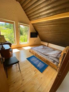Cama grande en habitación con techo de madera en Camping Nad Karpatamy SPA en Hrobyshche