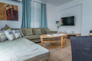 uma sala de estar com um sofá e uma mesa com uma televisão em Sun & Sand Private Villa em Protaras