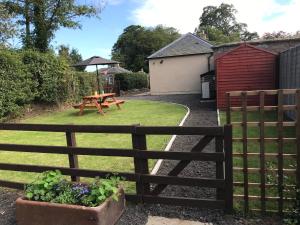 a garden with a wooden fence and a picnic table at The West Lodge -dog friendly, cosy, Scottish Borders cottage in Berwick-Upon-Tweed