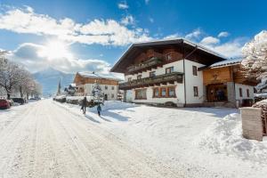 Un paio di persone che camminano per una strada ricoperta di neve di Holiday im Gästehaus Warter in Altenmarkt a Altenmarkt im Pongau