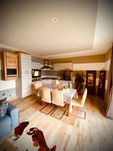 a living room with a dining table and a kitchen at Alice’s House in Fonteno