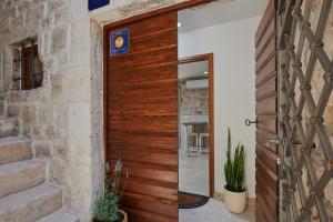 - une porte en bois dans une chambre dotée d'un mur en pierre dans l'établissement Villa Kudelik - Stone Story, à Trogir