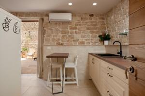 a kitchen with a small table and a sink at Villa Kudelik - Stone Story in Trogir