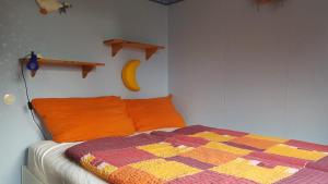 Un dormitorio con una cama con una manta y un plátano en la pared en Wohnen wie bei Freunden, en Braunlage