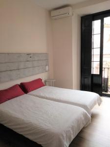 2 camas blancas en una habitación con ventana en Apartamento Centro Santa Catalina 1º B, en Sevilla