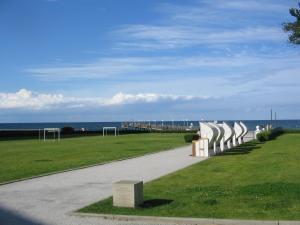 a walkway next to a field with a view of the ocean at Ferienwohnung PuraVida Ostsee 5A in Kühlungsborn