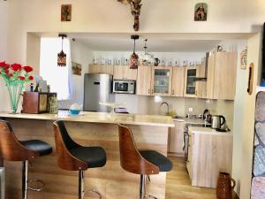 a kitchen with wooden cabinets and bar stools at Jaworzynka Nad Jeziorem in Ostaszewo