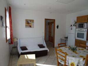 een woonkamer met een tafel en een keuken bij La vigne sous les pins in Castagniers
