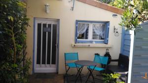 une table et des chaises devant une maison dans l'établissement Maisonnette Mimi, à Rochefort