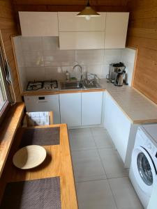 a small kitchen with a sink and a stove at Domek Mikołajki in Mikołajki