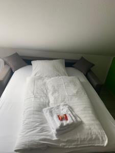 Hotel Unter den Linden في Kierspe: سرير ابيض وعليه بطانيه بيضاء