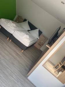een kleine slaapkamer met een bed en een spiegel bij Hotel Unter den Linden in Kierspe