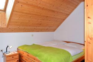 Łóżko w pokoju z drewnianym sufitem w obiekcie Ferienwohnung Wieserberg w mieście Dellach