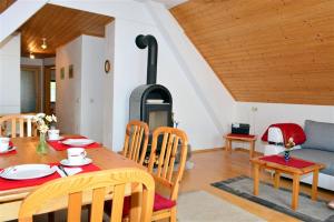 una sala da pranzo con tavolo e stufa a legna di Ferienwohnung Wieserberg a Dellach