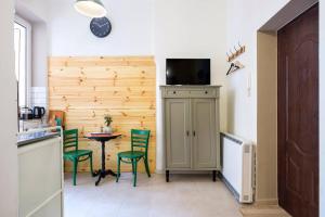 Small folksy studio Kochanowskiego St في كراكوف: مطبخ مع طاولة وكراسي خضراء في غرفة