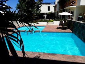 una piscina de agua azul frente a un edificio en Hotel Sierra Linda, en Xilitla