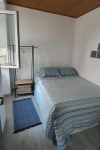 a bedroom with a bed and a blue rug at Vila Azul in Sesimbra