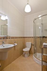 W łazience znajduje się toaleta, umywalka i prysznic. w obiekcie Pokoje Pinokio w mieście Darłowo