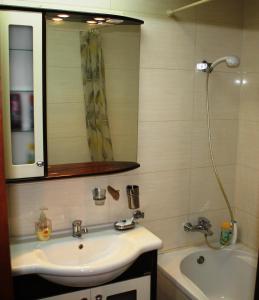 a bathroom with a sink and a mirror and a tub at City center Deluxe apartment in Bucharest