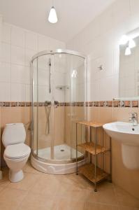 y baño con ducha, aseo y lavamanos. en Pokoje Pinokio, en Darłowo