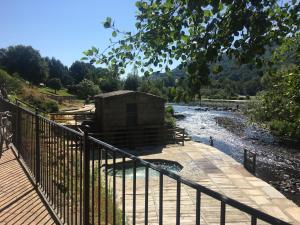 a wooden walkway next to a river with a building at Duplex Rosalia De Castro. Ribadavia in Ribadavia