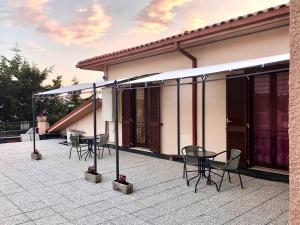 een patio met stoelen en tafels voor een huis bij Alloggio turistico Luigina in Morro Reatino