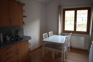 een keuken met een tafel en stoelen en een raam bij Appartement Claude in Châtillon
