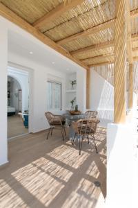 un soggiorno con soffitto in legno, tavolo e sedie. di Hora Seaside Suites a Naxos Chora