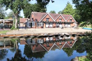 une maison avec une réflexion dans l'eau dans l'établissement Hinksey Heights, à Oxford