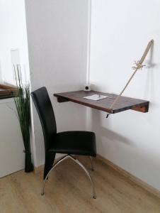 einen Schreibtisch mit einem Stuhl neben einer Wand in der Unterkunft Haus Monteiro in Elbigenalp